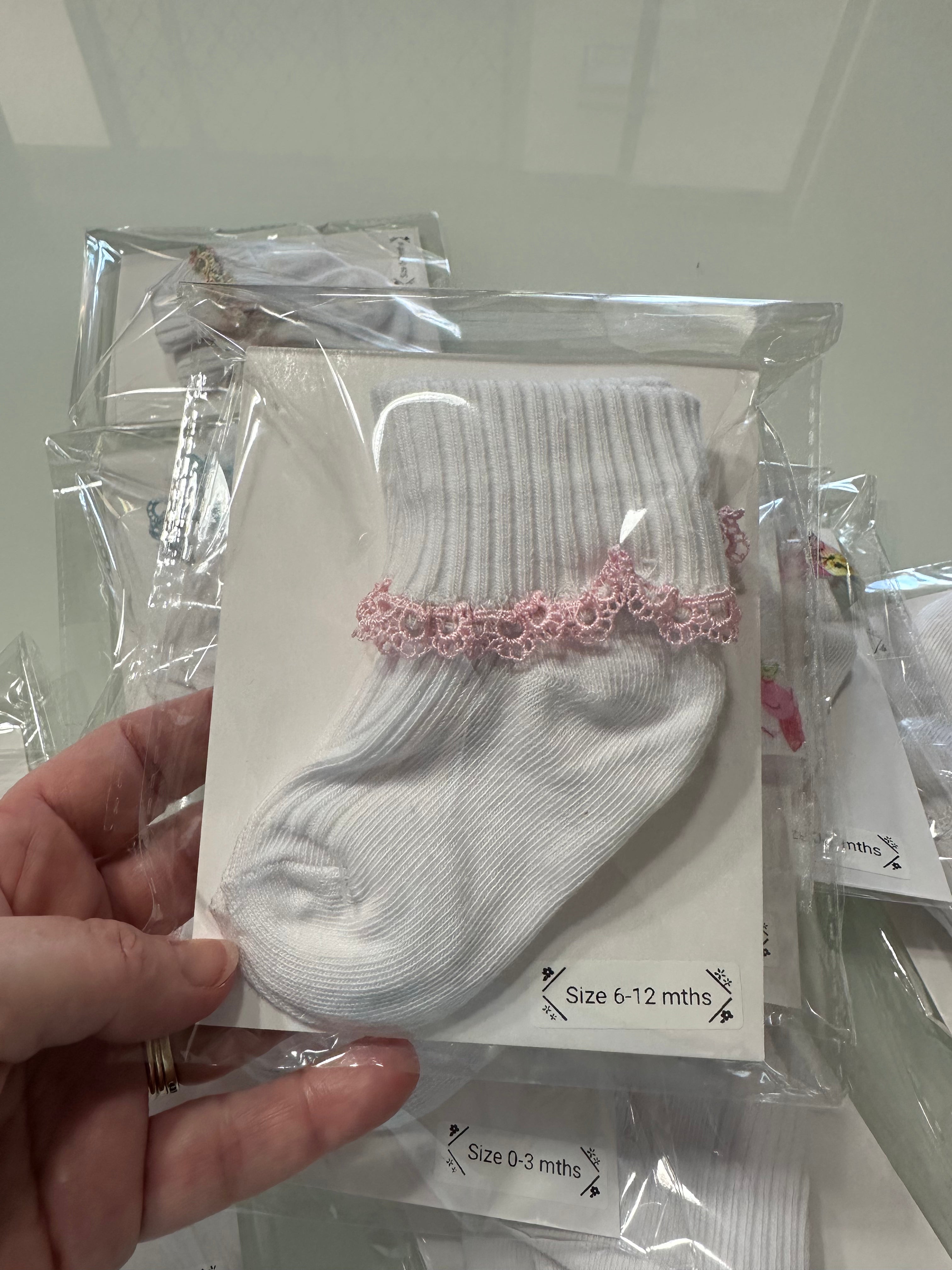 White baby cotton socks with pastel pink lace trim.