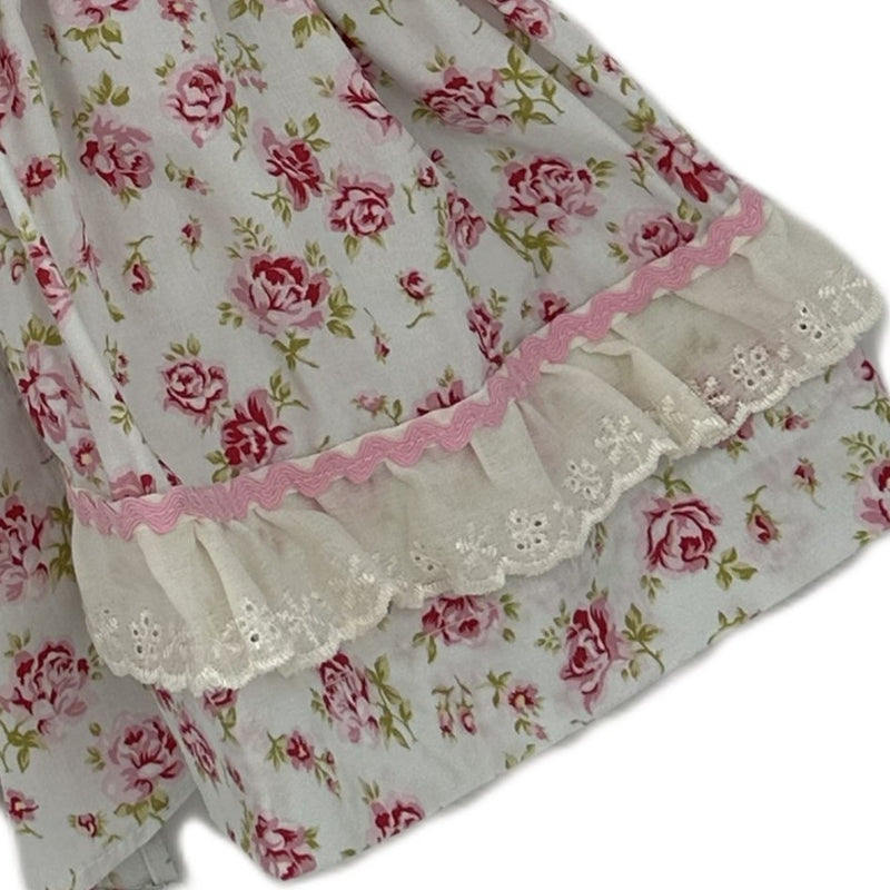 Floral fabric with pink roses and lace trim on a white background
